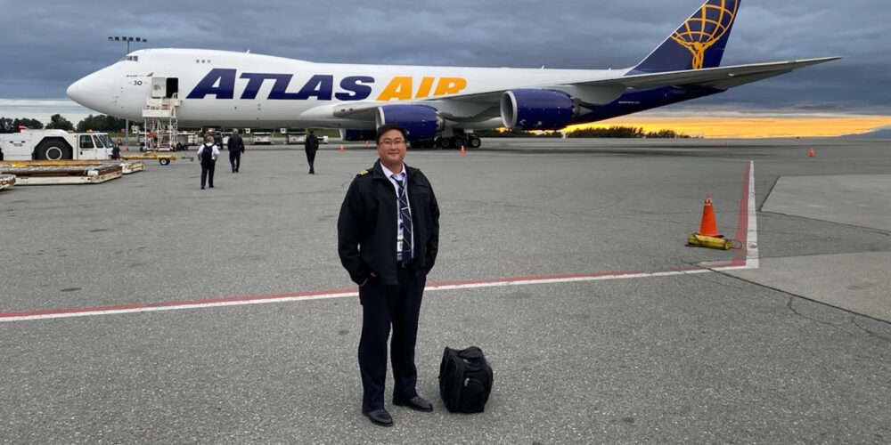 Alumnus Chris Awes stands in front of an Atlas Air jet.
