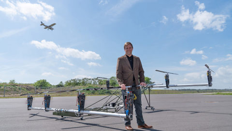Pat Anderson standing next to a large bare prototype multirotor airframe