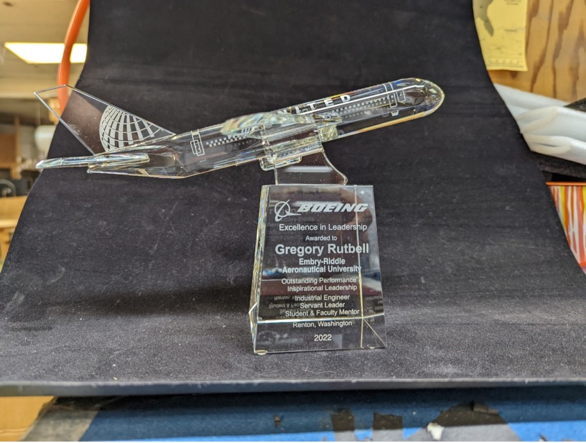 A picture of a crystal award shaped like a Boeing jet. It's honoring Greg Rutbell for being a top mentor.