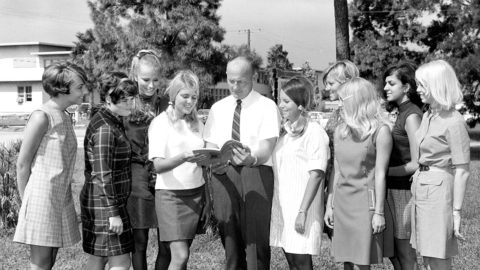 Women standing with a man holding a brochure