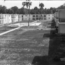 a black and white photo of an old dorm and courtyard