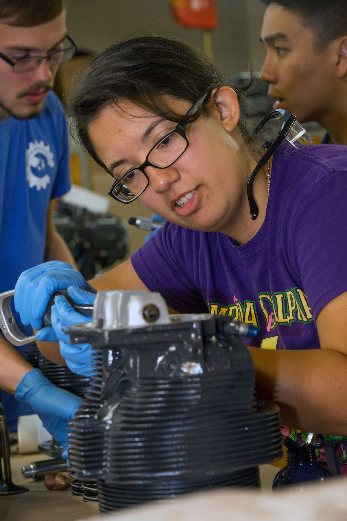 Paula Silva cleans a cylinder head before rebuilding the Lycoming airplane engine in the Chandler Titus Engine Repair Station. (Photo by David Massey)