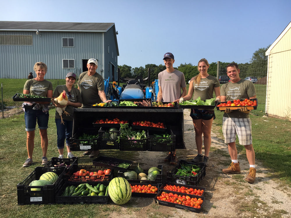 Farm volunteers standing behind a produce display