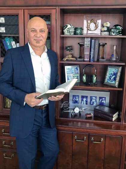 Constantine Marantidis standing by a shelf of memorabilia