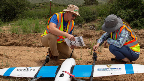 Two people preparing to launch a remote controlled drone in the Arizona high plains.