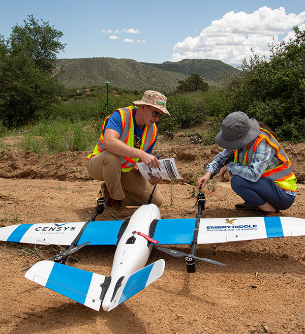 Two people preparing to launch a remote controlled drone in the Arizona high plains.