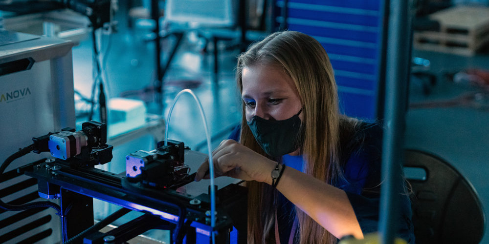Student working on a 3D printer in a university lab