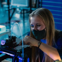 Student working on a 3D printer in a university lab