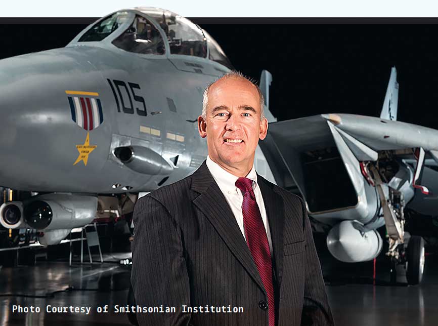 Chris Brown stands in front of fighter jet