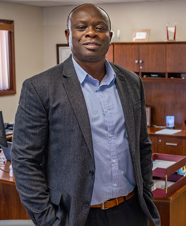 Ed Onwe, class of 2012, standing in his office