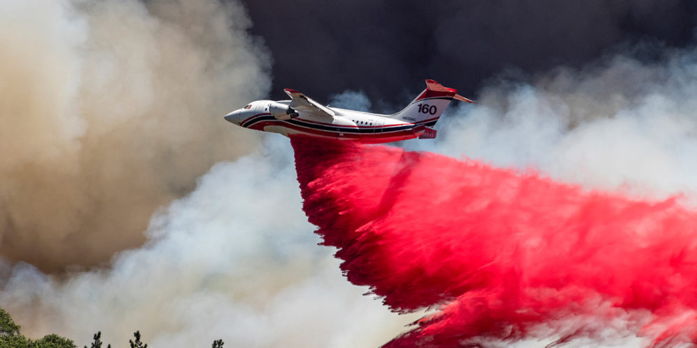 Avro RJ85 airtanker dropping retardant on a wildfire