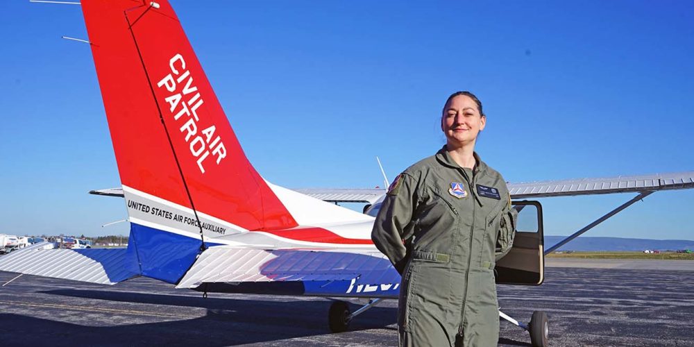 Woman in uniform next to a Civil Air Patrol airplane