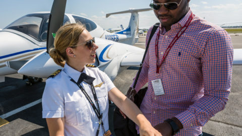 Flight instructor Abby Pasmore works with Eric Tetteh to pre-flight a Diamond DA42.
