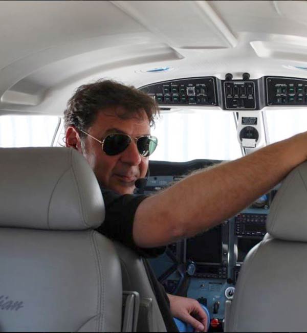 Pantelis Vassiliou, class of '86, in the left seat of an airplane cockpit.