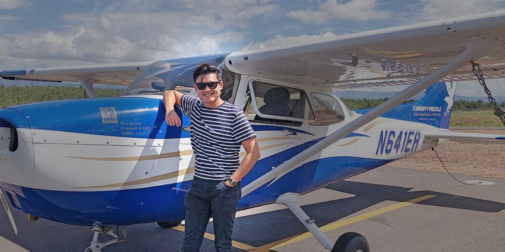 Khairul Afiq Zolkafli, an Embry-Riddle student, standing next to an Embry-Riddle Cessna airplane.