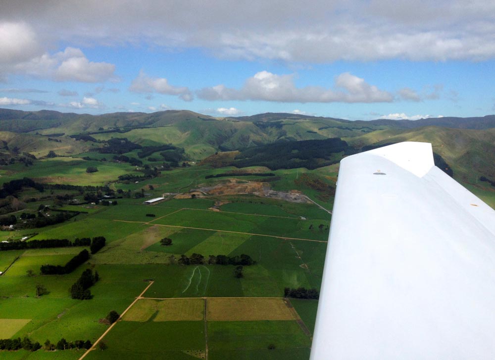 Aerial view of the New Zealand countryside with airplane wing in the foreground.