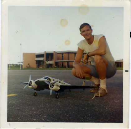 Tom Isenburg ('70) with a model plane at the Daytona Beach Campus.