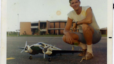 Tom Isenburg ('70) with a model plane at the Daytona Beach Campus.