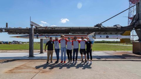 Students and faculty stand in front of the SpEED Demon rocket they worked on with NASA.