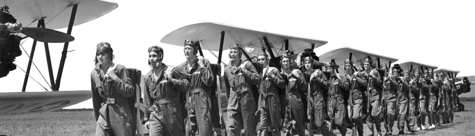 WWII pilots in training stand in front of aircraft