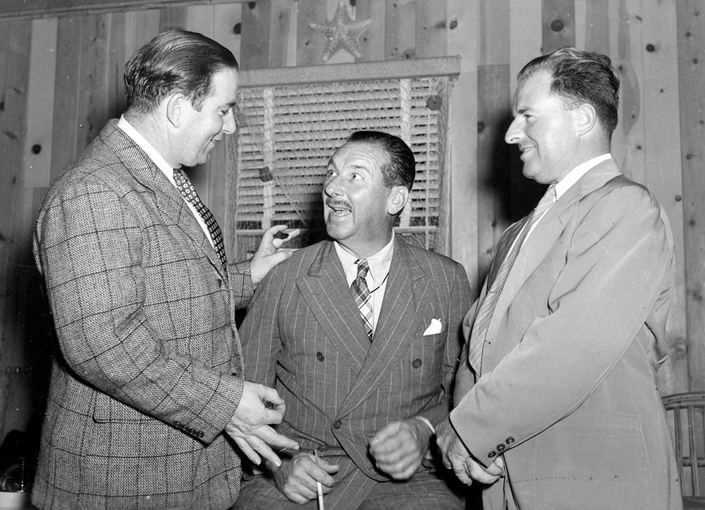 Black and white photo of Len Povey, John McKay and Willis Tyson wearing suits and laughing together