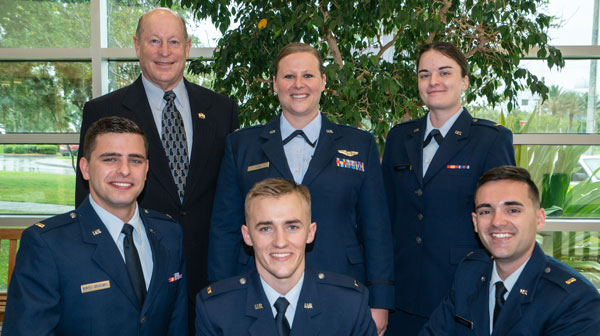 Nikki Yogi, Chuck Graf and four AFROTC cadets in uniform.