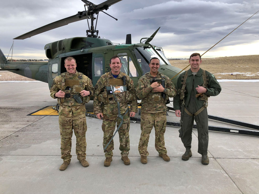 Four air force servicemen standing in front of a helicopter.